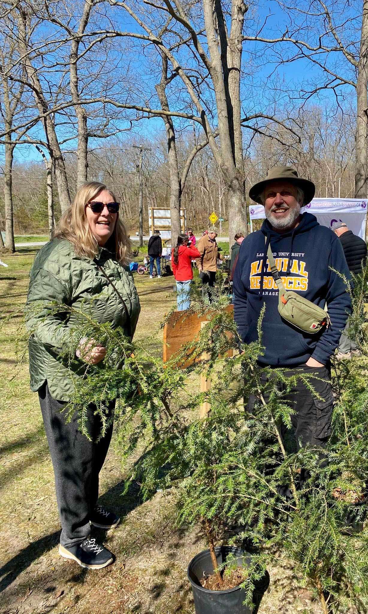 James Corcoran of Hemlock Grove Tree Nursery with a customer holding hemlock seedlings at a LEN sale