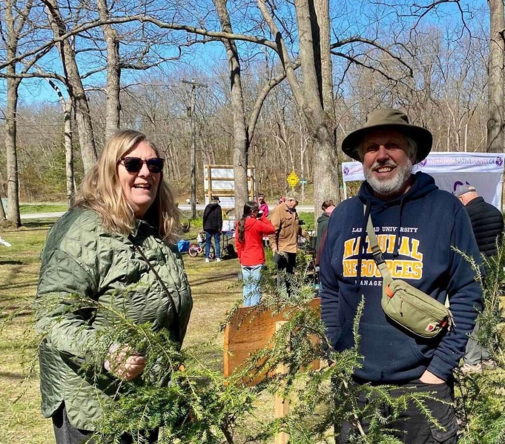 James Corcoran of Hemlock Grove Tree Nursery with a customer holding hemlock seedlings at a LEN sale